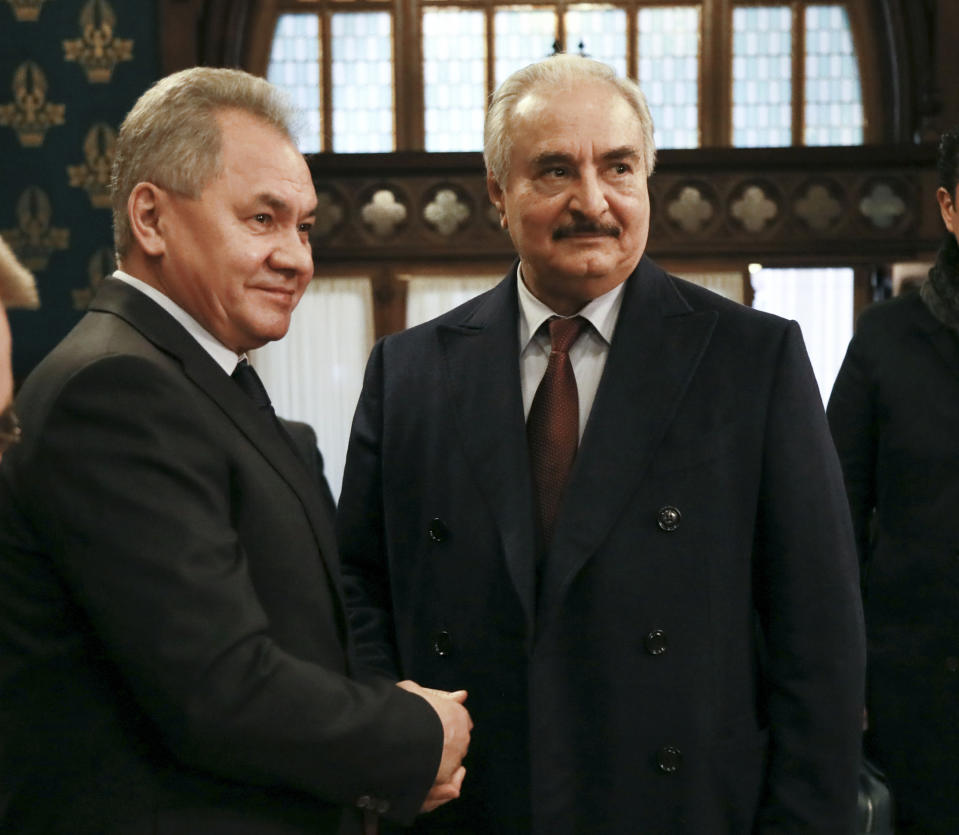 In this handout photo released by Russian Foreign Ministry Press Service, Russian Defense Minister Sergei Shoigu, left, shakes hands with Khalifa Hifter, the head of the self-styled Libyan National Army prior to the talks in Moscow, Russia, Monday, Jan. 13, 2020. Foreign and defense ministers of Russia and Turkey met as part of an effort by Moscow and Ankara to sponsor Monday's talks between rival parties in Libya in the Russian capital. (Russian Foreign Ministry Press Service via AP)