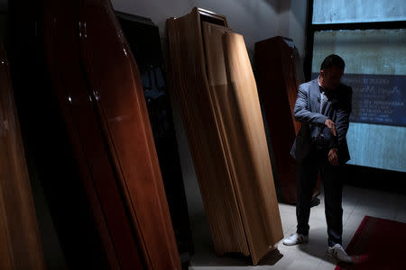 FILE PHOTO: Undertaker and candidate for town councillor at the municipality of Sykies, Konstantinos Baboulas, stands next to coffins at his family's funeral parlor in Thessaloniki, Greece, May 17, 2019. REUTERS/Alkis Konstantinidis