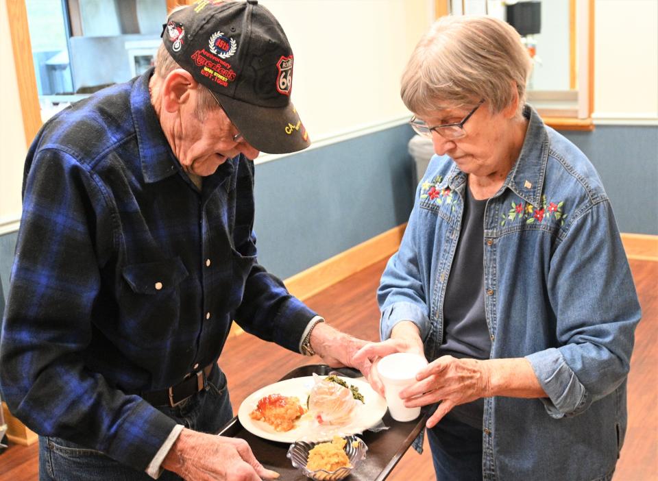 Volunteers help put drinks on trays for seniors at the Burnside congregate meals lunches.