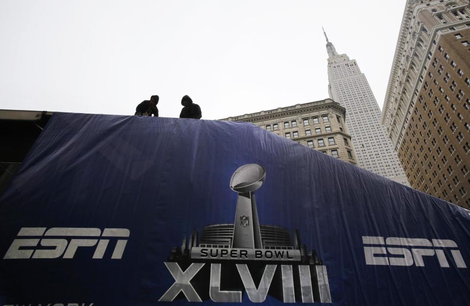 Workers install a studio for ESPN in Herald Square, Sunday, Jan. 26, 2014, in New York. A dozen blocks of Broadway, in the heart of Manhattan, will close to traffic for four days so the NFL can host a Super Bowl festival. The NFL's championship game between the Denver Broncos and Seattle Seahawks is Sunday, Feb. 3 in East Rutherford, N.J. (AP Photo/Mark Lennihan)