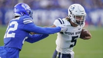 Utah State quarterback Cooper Legas (5) carries the ball he breaks free from BYU defensive back Ammon Hannemann (22) on his way to a touchdown during the first half of an NCAA college football game Thursday, Sept. 29, 2022, in Provo, Utah. (AP Photo/Rick Bowmer)