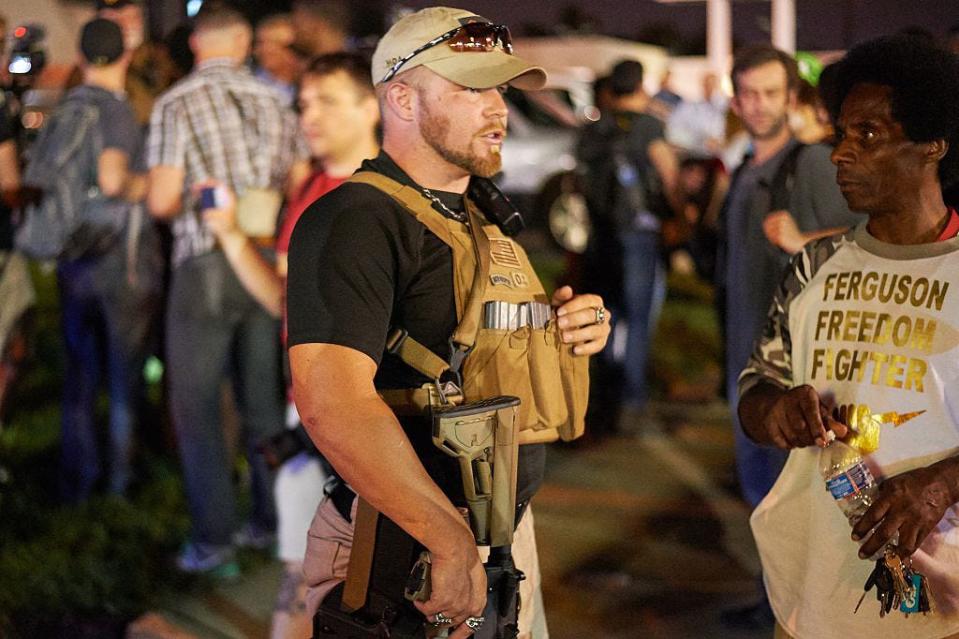 A member of the Oath Keepers walks with his personal weapon on the street during protests in Ferguson, Missouri, on Aug. 10, 2015. The unrest stemmed from the first anniversary of the police shooting of Michael Brown, an unarmed Black teen.