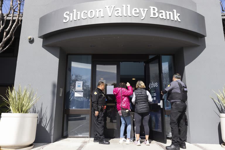 Guardias de seguridad permiten a personas ingresar en la sede del Silicon Valley Bank en Santa Clara, California, el lunes 13 de marzo de 2023. (AP Foto/ Benjamin Fanjoy)