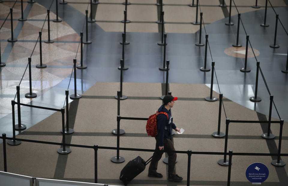 Una persona se dirige al puesto de seguridad en el Aeropuerto Internacional de Denver mientras los viajeros se quedan en casa para frenar la propagación del nuevo coronavirus, el miércoles 18 de marzo de 2020. (AP Foto/David Zalubowski)