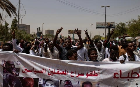 Protesters hold a banner calling for the release of political prisoners on Wednesday - Credit: Salih Basheer/AP