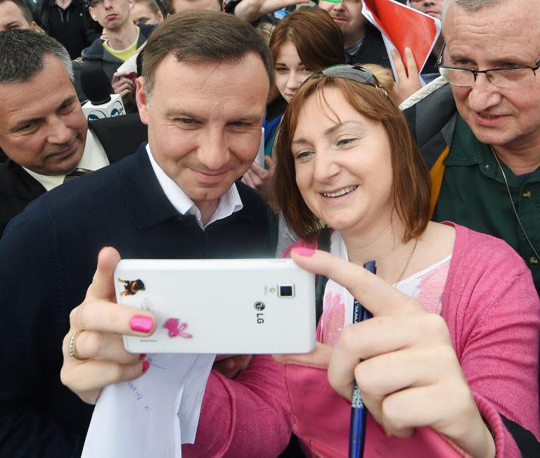 President elect Andrzej Duda (L) poses for a selfie with residents of Warsaw on May 25, 2015