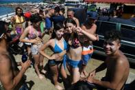 Teenagers pose at Bahia de los Ninos beach in La Guaira