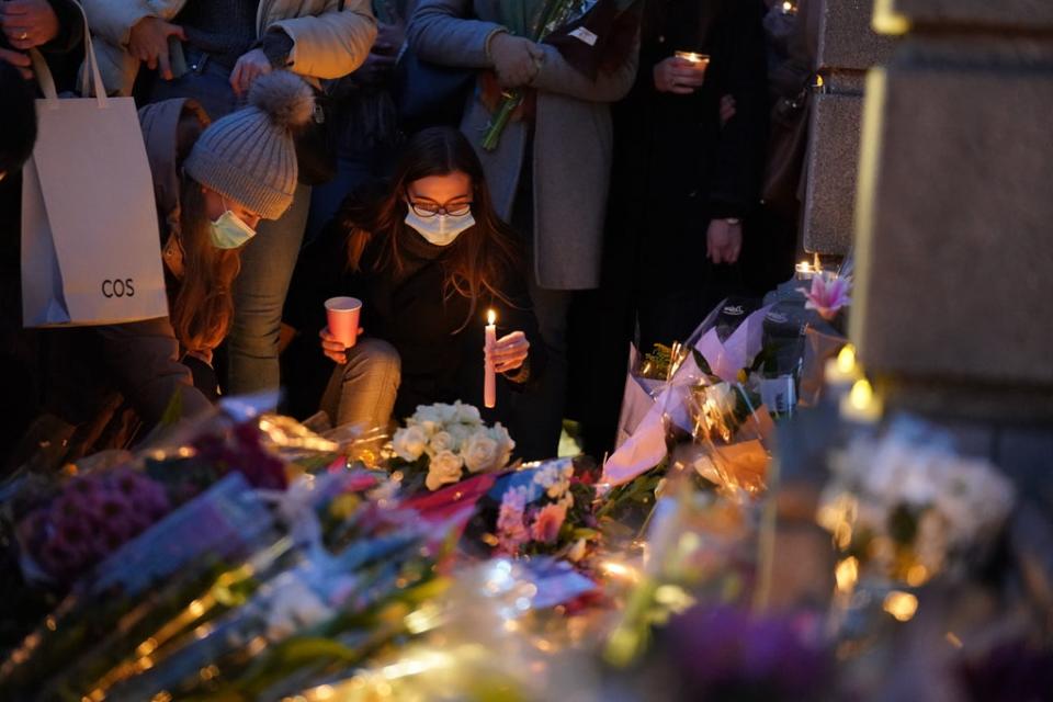 A woman lights a candle after attending  a vigil at Leinster House, Dublin (PA)