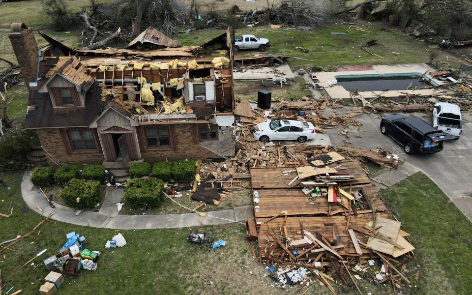 Debris is strewn about a tornado damaged home - AP Photo/Julio Cortez