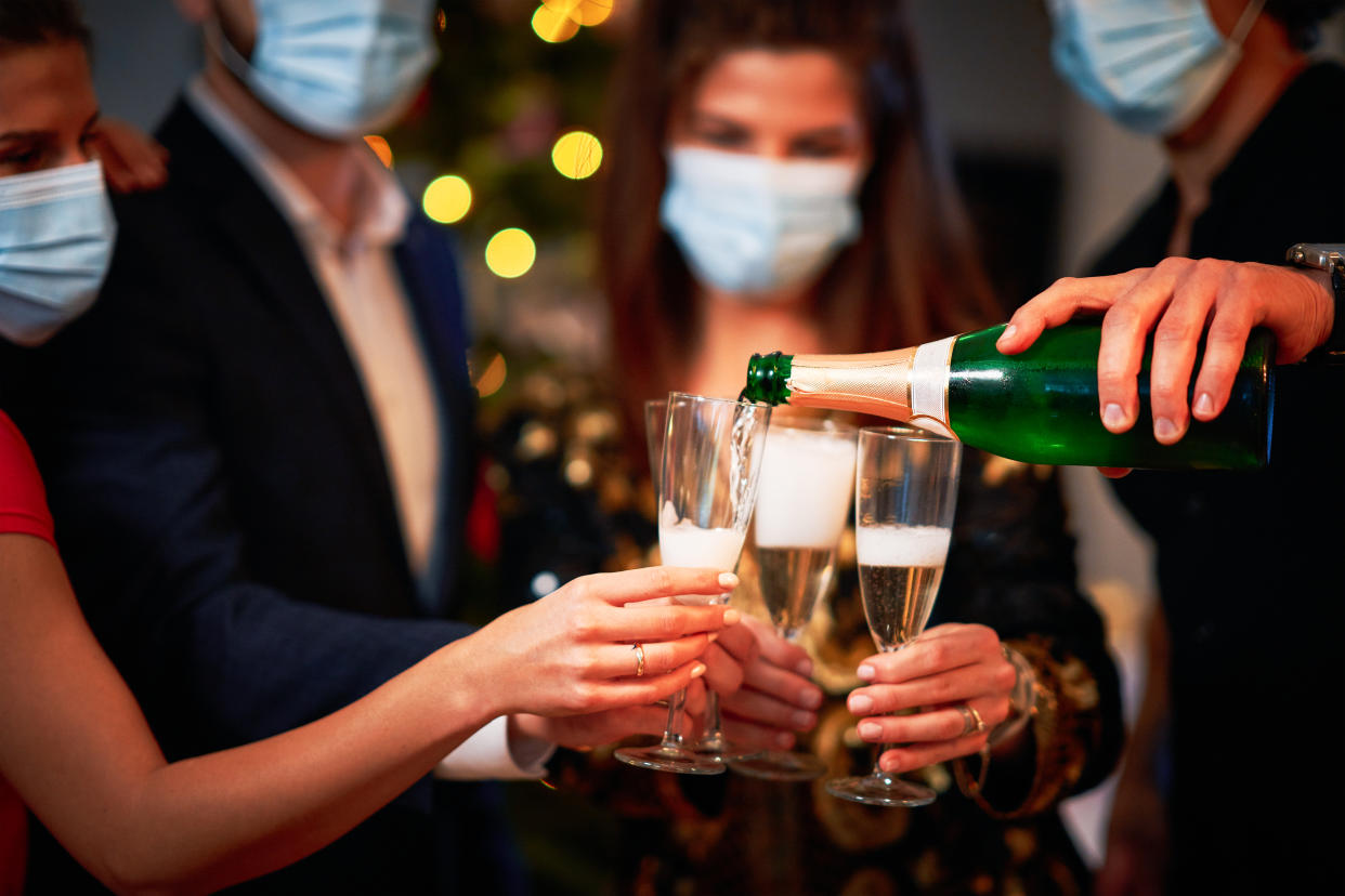 Two beautiful young couples having fun at New Year's Eve Party holding numbers 2020