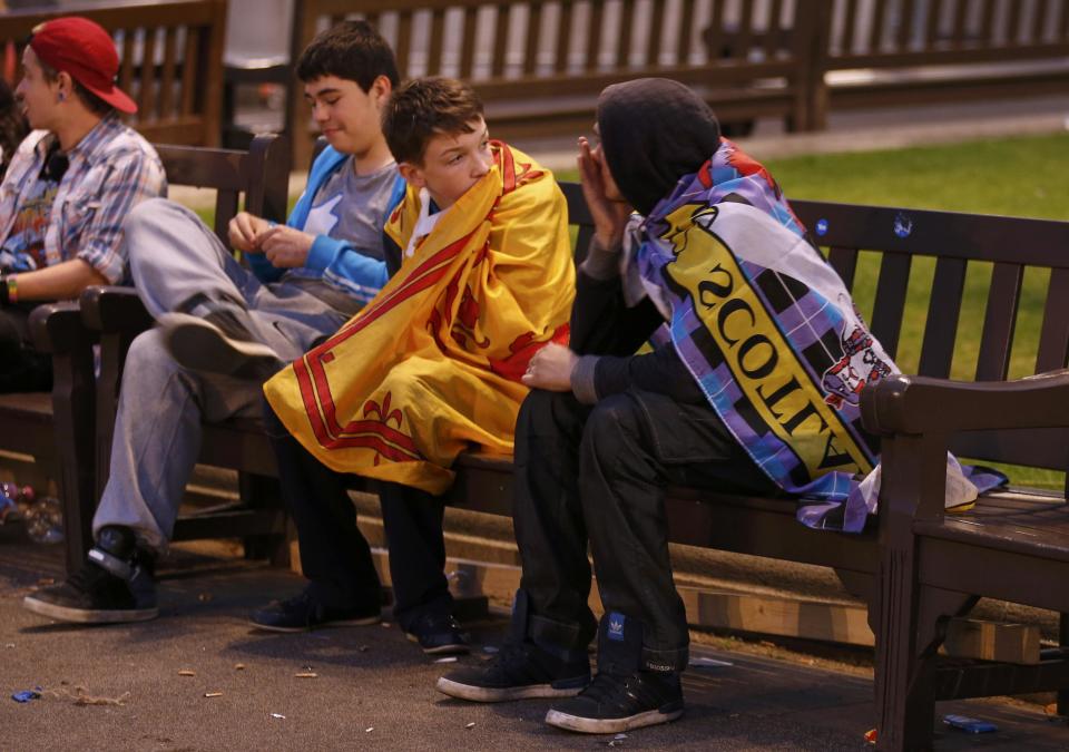 Supporters from the "Yes" Campaign react as they sit in George Square in Glasgow, Scotland