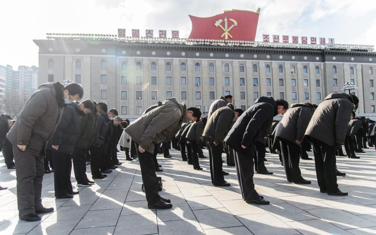 People bow during a three minutes silence to mark the ten-year anniversary of the death of Kim Jong-Il in December 2021 - AFP