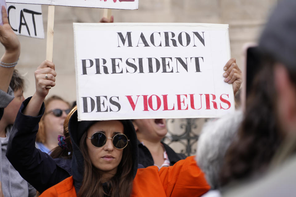 A woman shows a poster reading "Macron, President of rapists" during a demonstration organized by a feminist association called the Observatory on Sexual and Gender-based violence in politics, Tuesday, May 24, 2022 in Paris. Rape accusations against a newly named French government minister have galvanized a movement aimed at exposing sexual misconduct in French politics and encouraging women to speak out against abusers. (AP Photo/Nicolas Garriga)