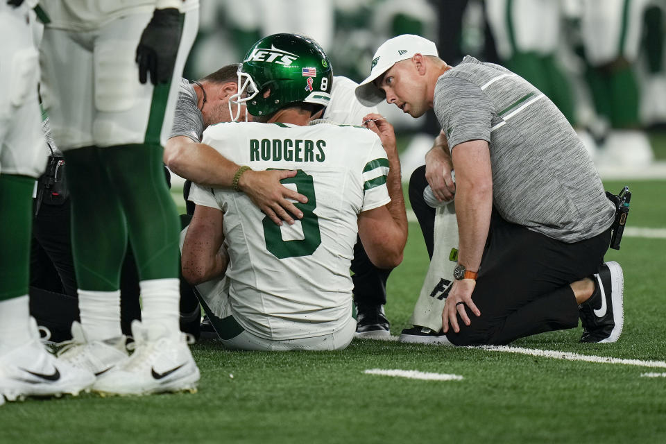 New York Jets quarterback Aaron Rodgers (8) is tended to on the field during the first quarter of Monday's game against the Buffalo Bills, in East Rutherford, N.J. (AP Photo/Seth Wenig)