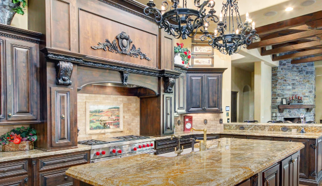 Large "tuscan" style kitchen with massive, dark wood features and dark granite countertops