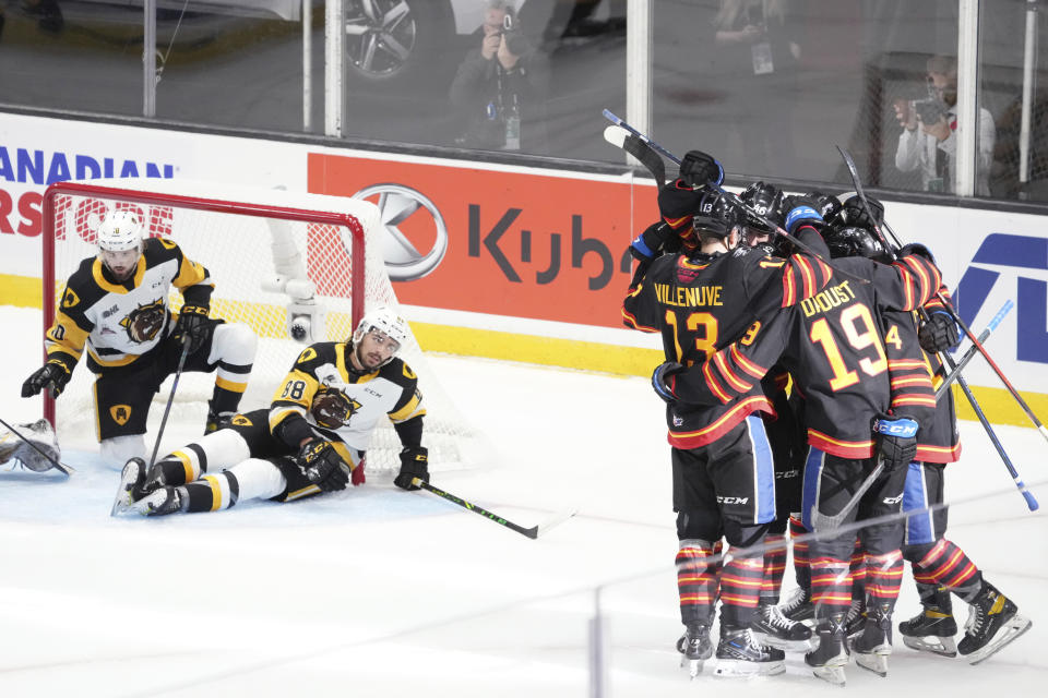 Members of the Saint John Sea Dogs celebrate a goal by teammate Raivis Kristians Ansons in front of Hamilton Bulldogs' Gavin White, left, and teammate Mark Duarte during the first period of a Memorial Cup hockey game in Saint John, Canada, on Monday, June 20, 2022. (Darren Calabrese/The Canadian Press via AP)