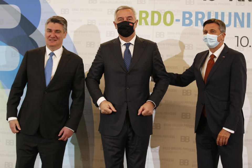 Croatian President Zoran Milanovic, left, and Slovenia's President Borut Pahor, right, pose for cameras with Montenegro's President Milo Djukanovic at the Brdo-Brijuni summit, in Brdo, Slovenia, Monday, May 17, 2021. The Brdo-Brijuni Process summit had originally been planned for last year, to coincide with the 10th anniversary of the initiative, but had been postponed twice due to the coronavirus pandemic. (AP Photo/Darko Bandic)