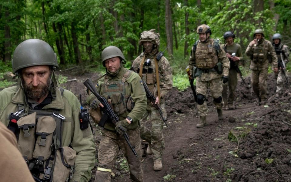 Ukrainian servicemen walk in the forest near a recently retaken village, north of Kharkiv, on May 15 - Mstyslav Chernov/AP