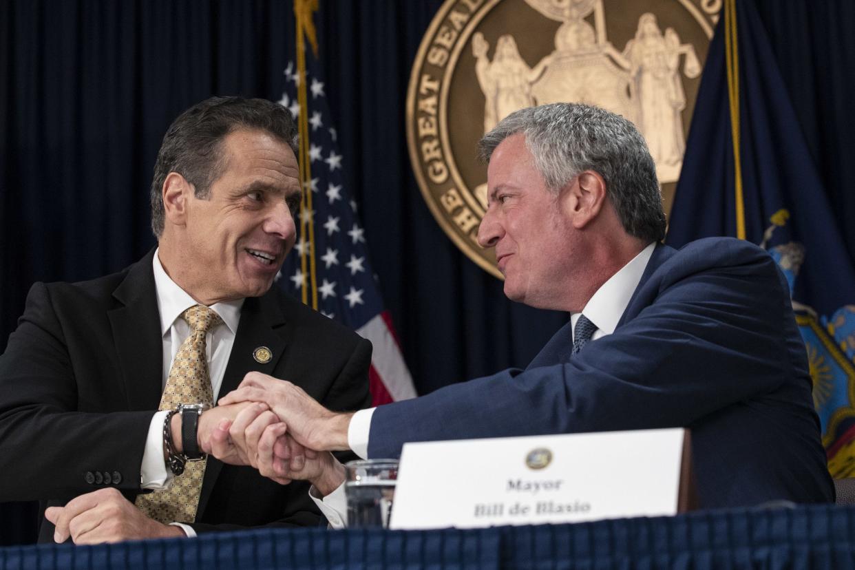 (L-R) New York Governor Andrew Cuomo and New York City Mayor Bill de Blasio shake hands during a press conference to discuss Amazon's decision to bring a new corporate location to New York on November 13, 2018. While de Blasio was initially for the company setting up shop in Queens, he ultimately sided with residents and their distain.