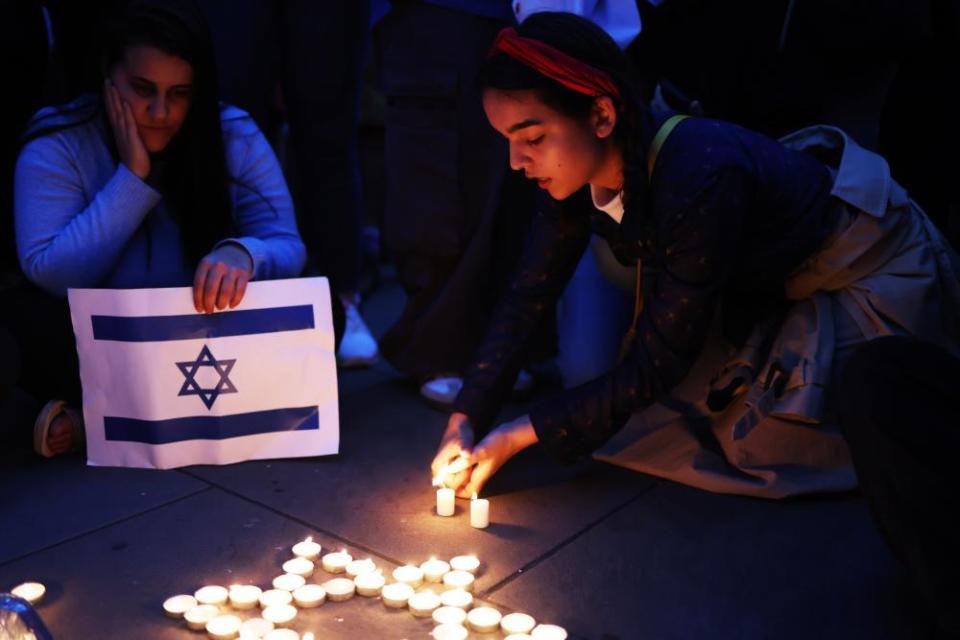 A woman lights a candle during the vigil in London this week.