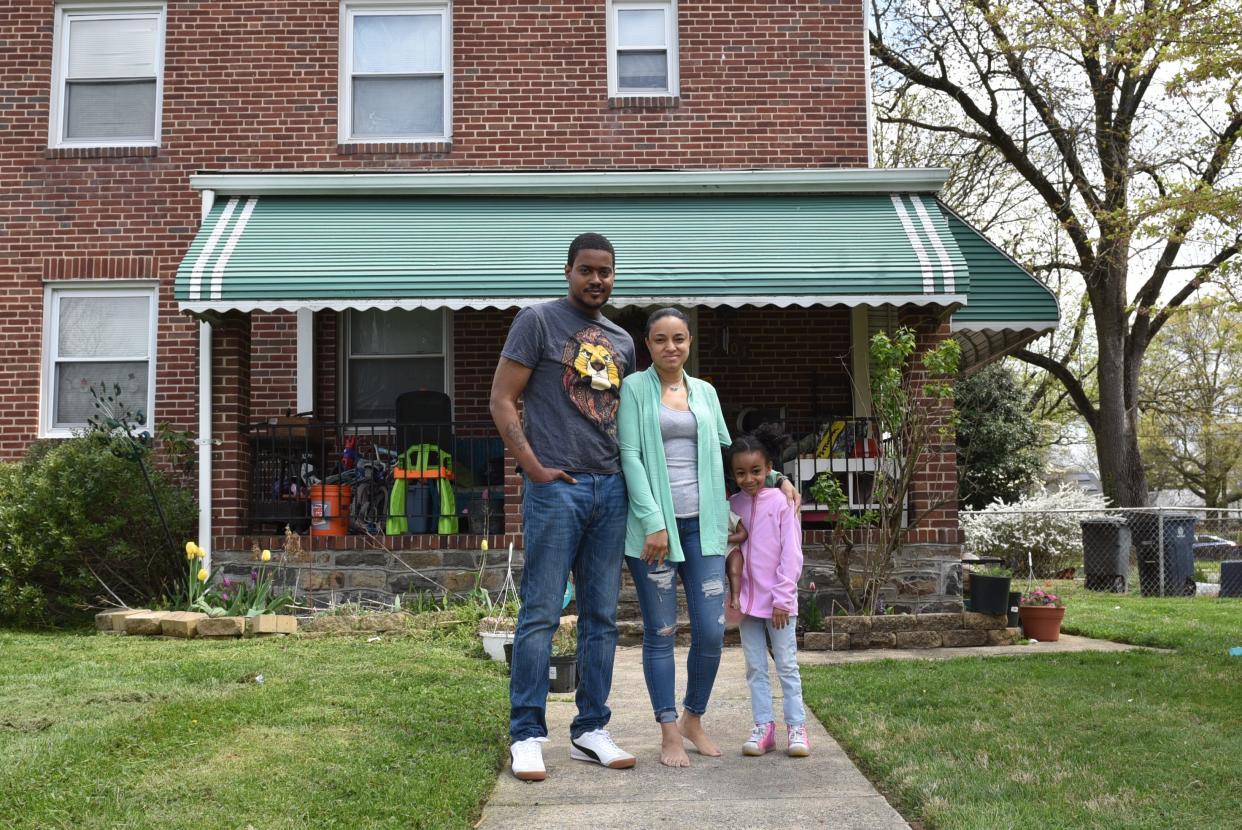 Tony Murray, wife Leah Brown, and daughter Tierney stand outside of their Northwest Baltimore home on April 13, 2021. The family has experienced numerous sewage backups through their basement toilet in recent years, costing them thousands of dollars.