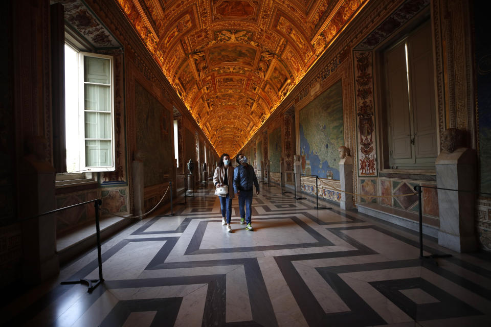 Visitors wearing masks to prevent the spread of coronavirus walks inside the Vatican Museum after it reopened, in Rome, Monday, May 3, 2021. The Vatican Museums reopened Monday to visitors after a shutdown following COVID-19 containment measures. (AP Photo/Alessandra Tarantino)