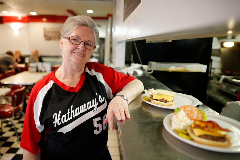 Long-time server Geneva Huff poses for a photo in the order window at Hathaway's Diner in 2019.