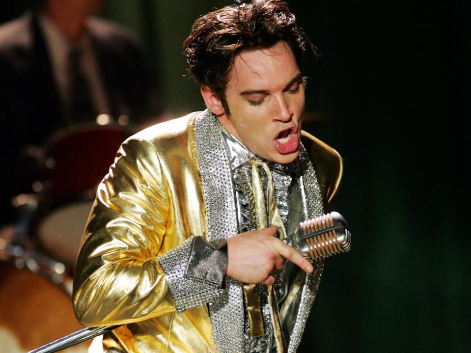 Jonathan Rhys Meyers playing Elvis Presley holding a microphone