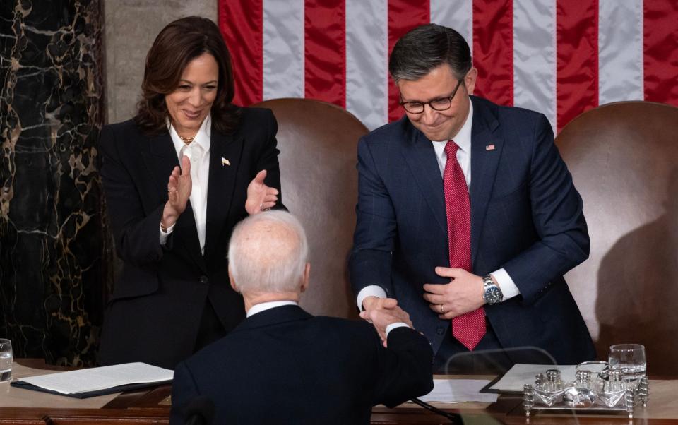 Kamala Harris, left, the Vice-President, and Mike Johnson, the Speaker of the House, congratulate Mr Biden on his speech