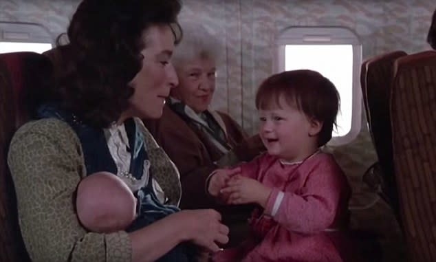 baby Mamie sitting on the lap of a woman on a plane