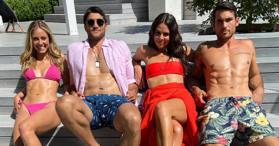 Home and Away cast pose for a photo in swimwear, from the left: Jacqui Purvis in a pink bikini, Ethan Browne in blue swim trunks and a pink shirt, Emily Weir in a red bandeau top and skirt, Nicholas Cartwright in green swim trunks with a floral and leaf print