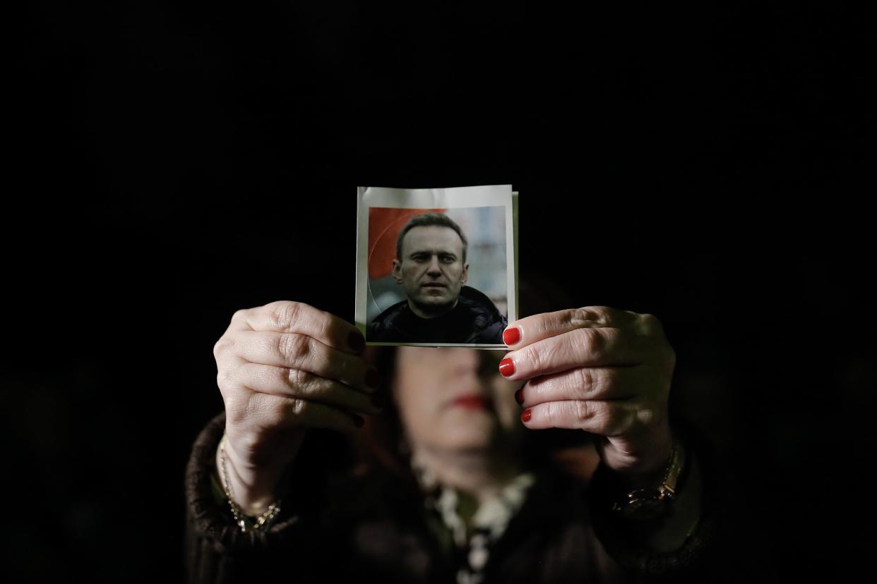 A protester holding a photo of late Russian opposition leader Alexei Navalny attends a rally to commemorate his death, outside the Russian Embassy in Athens, Greece, 19 February 2024 (EPA)