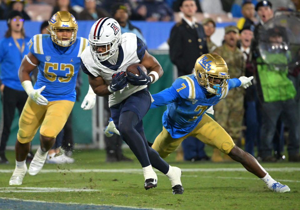 Nov 12, 2022; Pasadena, California, USA; Arizona Wildcats running back Michael Wiley (6) gets past UCLA Bruins linebacker Darius Muasau (53) UCLA Bruins defensive back Mo Osling III (7) as he runs into the end zone for a touchdown in the first half at the Rose Bowl. Mandatory Credit: Jayne Kamin-Oncea-USA TODAY Sports