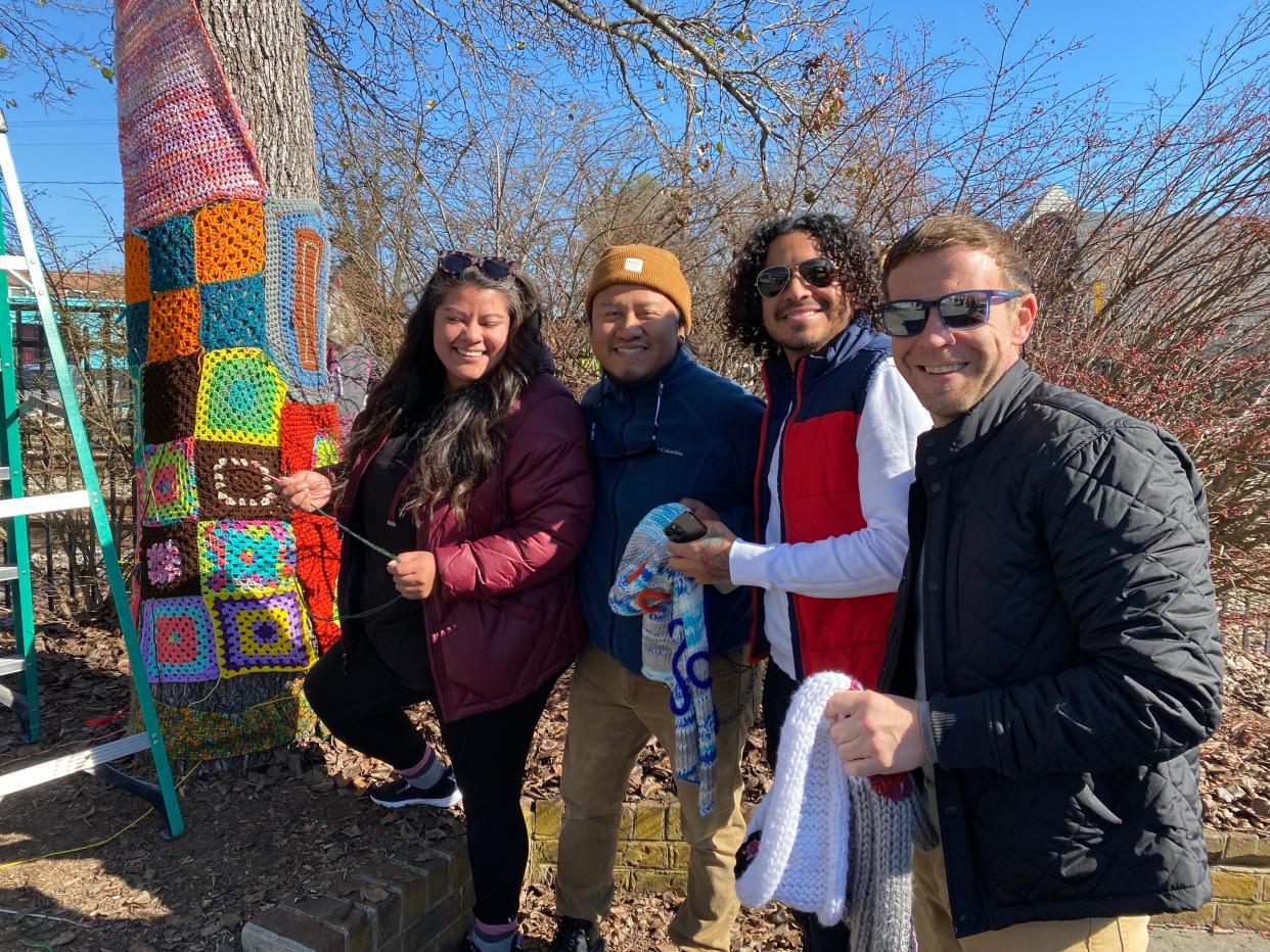 People participate in STEAP's CommuniTREES Yarn Art Project. The art is on display through early April.