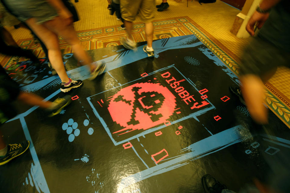 People walk past a floor graphic during the Def Con hacker convention in Las Vegas, Nevada, U.S. on July 29, 2017. REUTERS/Steve Marcus