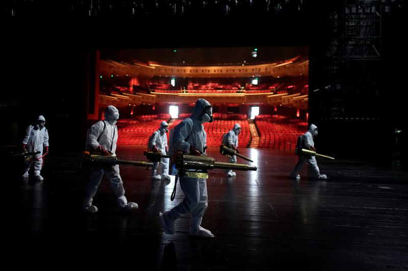 Volunteers from the Blue Sky Rescue team disinfect at the Qintai Grand Theatre in Wuhan