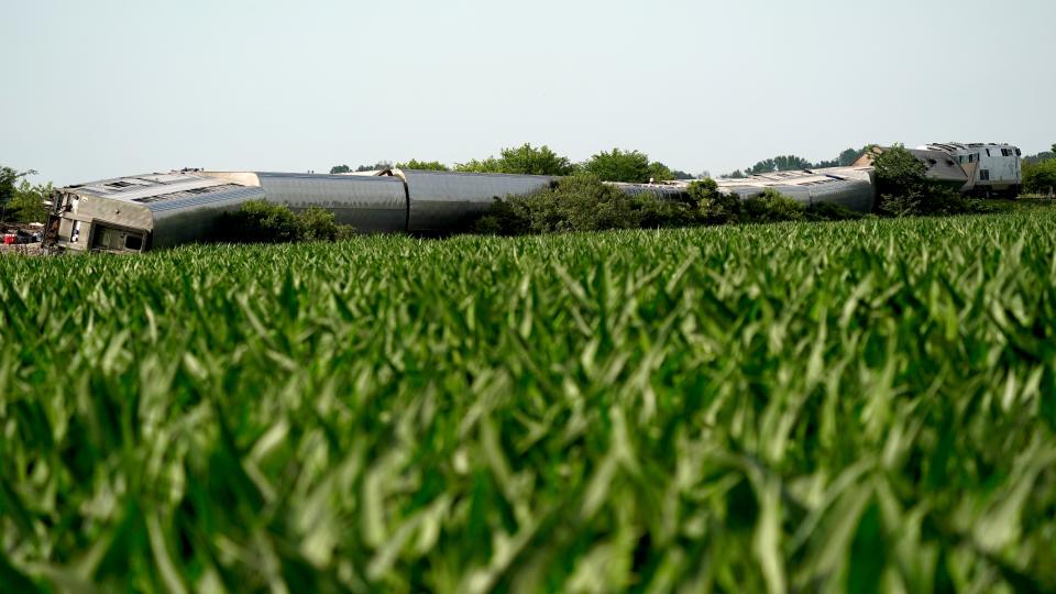 An Amtrak train that derailed after striking a dump truck is seen beyond a corn field Monday near Mendon, Mo.