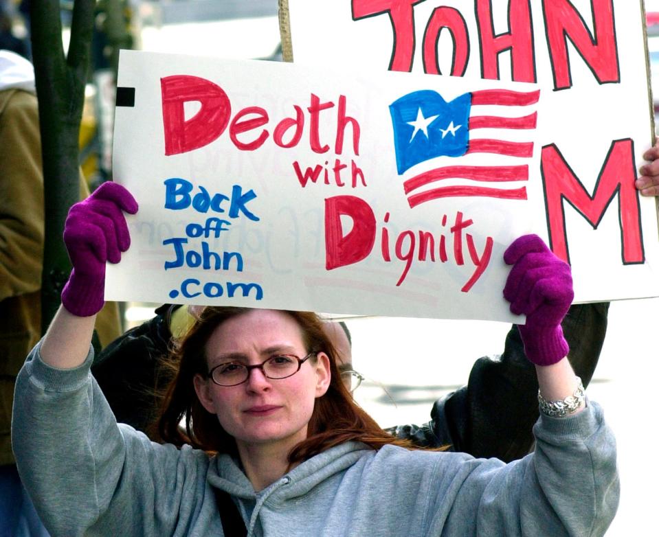 In this March 22, 2002, file photo, Stacey Richter holds a sign outside a federal courthouse in Portland, Ore., during a hearing on the fate of Oregon's physician-assisted suicide law.