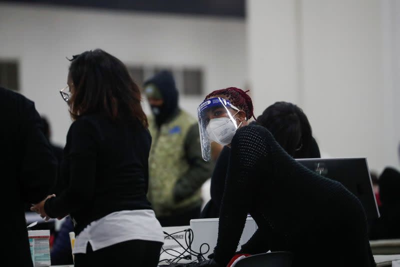 A poll worker wears a face shield as votes continue to be counted at the TCF Center the day after the 2020 U.S. presidential election, in Detroit, Michigan