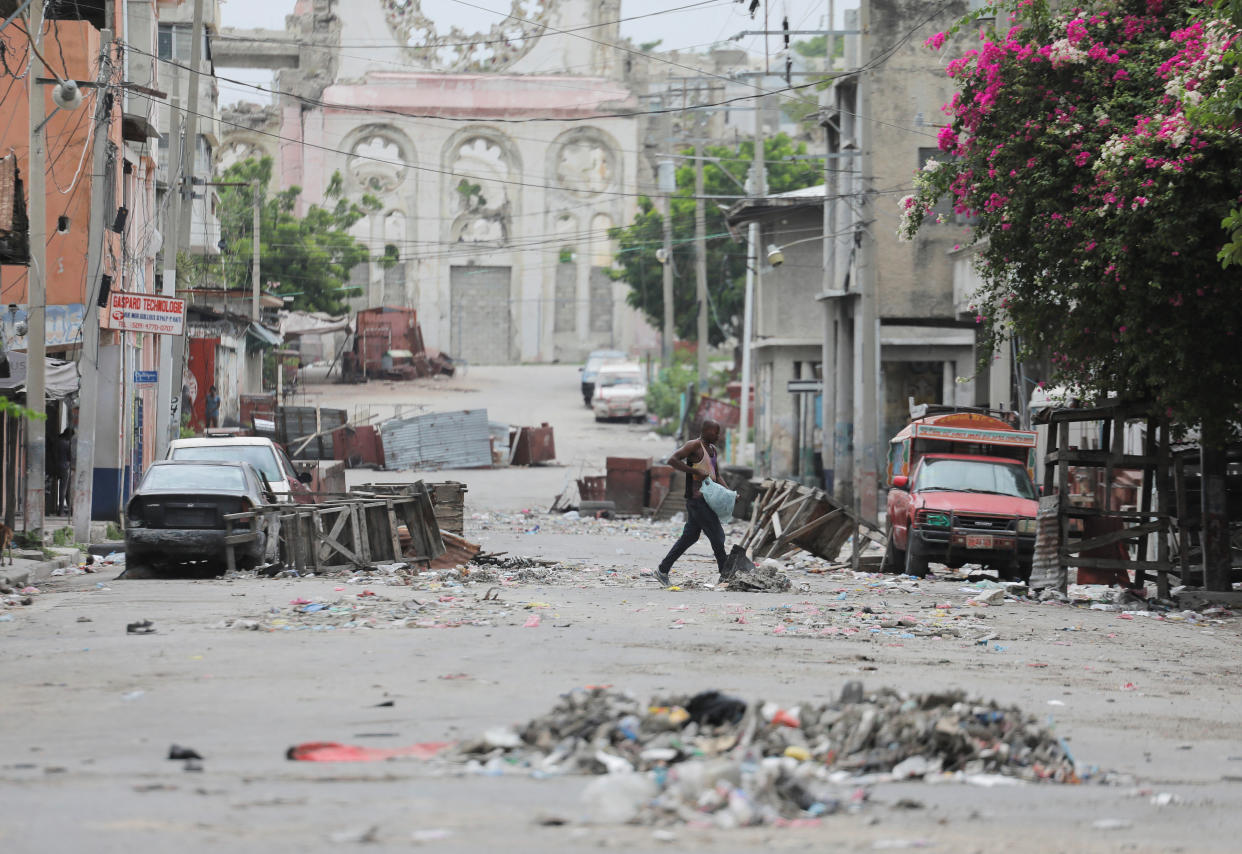 A man walks between road blocks in downtown Port-au-Prince.