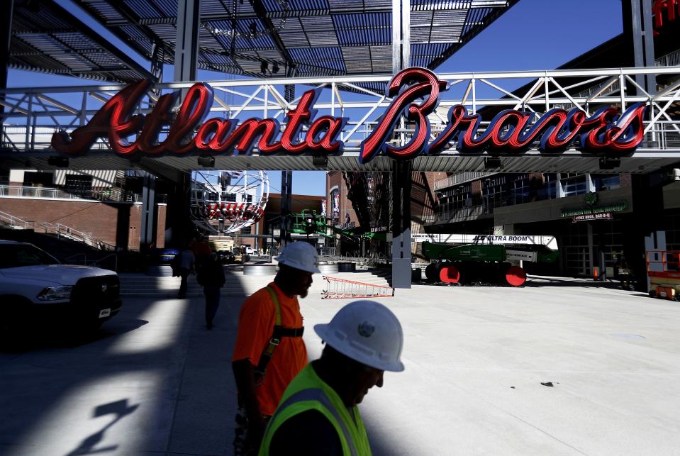 Construction workers walk past a mixed-use area to feature restaurants and retail stores at SunTrust Park, the Atlanta Braves’ new baseball stadium in Atlanta.