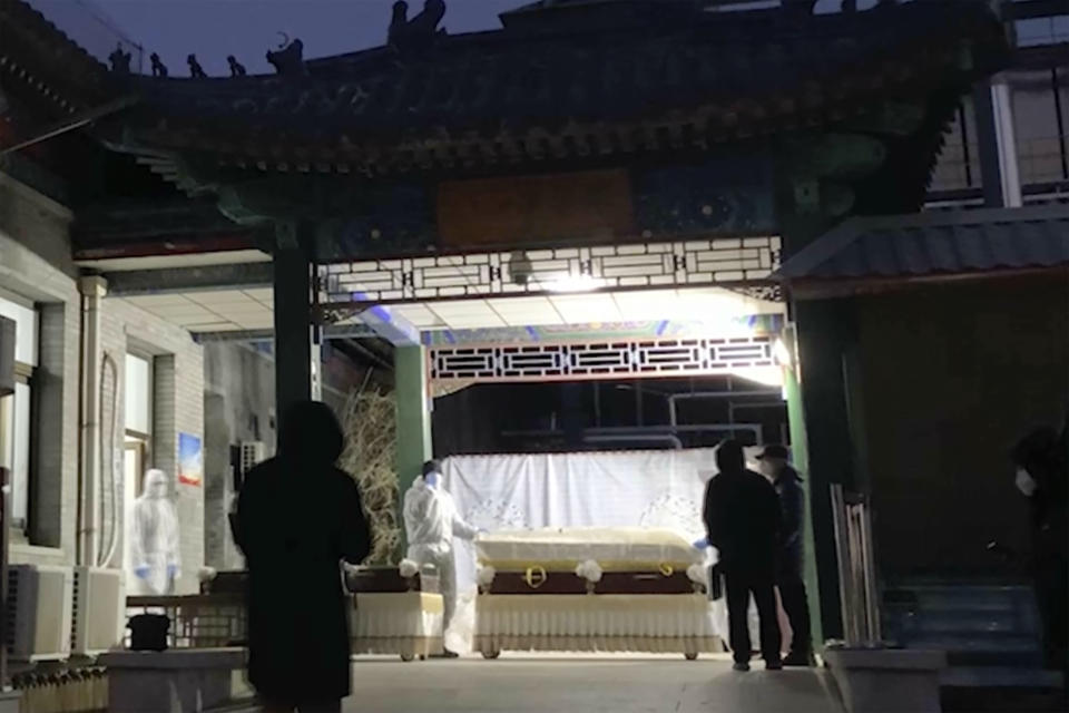 Workers move caskets at a funeral complex in Beijing, Friday, Dec. 16, 2022. Deaths linked to COVID are beginning to appear in China, even as those deaths are not reflected in the official tally. Relatives of people who died in Beijing said their loved ones had tested positive for the coronavirus before their deaths, while employees at shops in one funeral complex said there has been a noticeable uptick in traffic in the past few days. (AP Photo/Dake Kang)