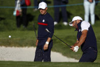 FILE - In this Sept. 25, 2018, file photo, the United States' Jordan Spieth,left, watches as Dustin Johnson plays from a bunker on the third hole during practice at the Ryder Cup golf matches at Le Golf National in Guyancourt, outside Paris, France. The 2020 U.S. Ryder Cup team includes veterans Johnson and Spieth — the only Americans to have played at least three Ryder Cups. (AP Photo/Alastair Grant, File)