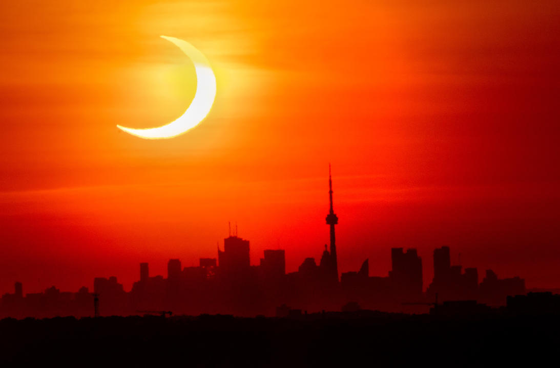 An annular solar eclipse rises over the skyline of Toronto on Thursday, June 10, 2021. THE CANADIAN PRESS/Frank Gunn