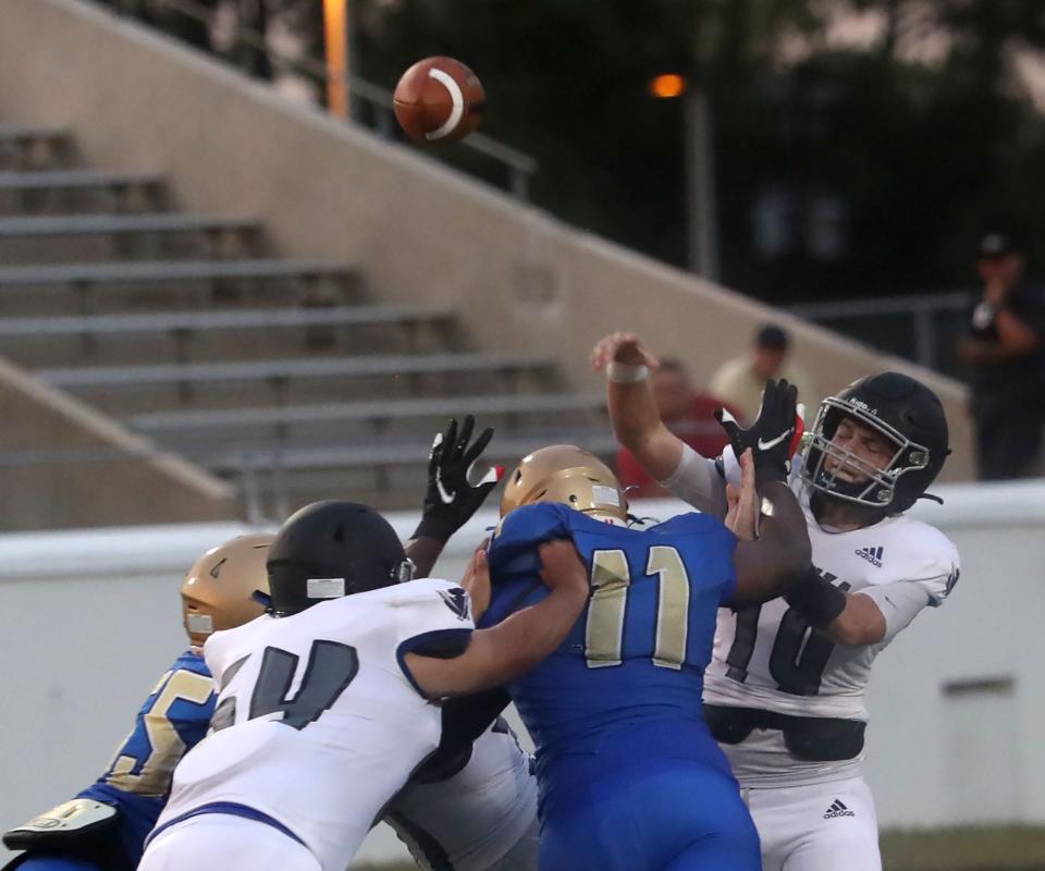 Matanzas High's QB Jackson Lundahl #19 gets a pass off undser heavy pressure from the Mainland High line, Friday Auigust 18, 2023 in Daytona Beach.