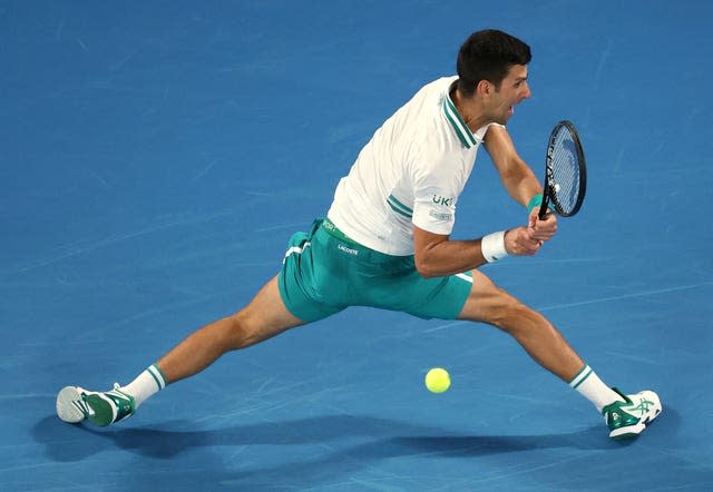Novak Djokovic stretches to hit a backhand behind his back