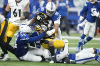 Pittsburgh Steelers' Anthony McFarland Jr. is tackled by Indianapolis Colts' Grover Stewart (90) and Dayo Odeyingbo during the second half of an NFL football game, Monday, Nov. 28, 2022, in Indianapolis. (AP Photo/Michael Conroy)