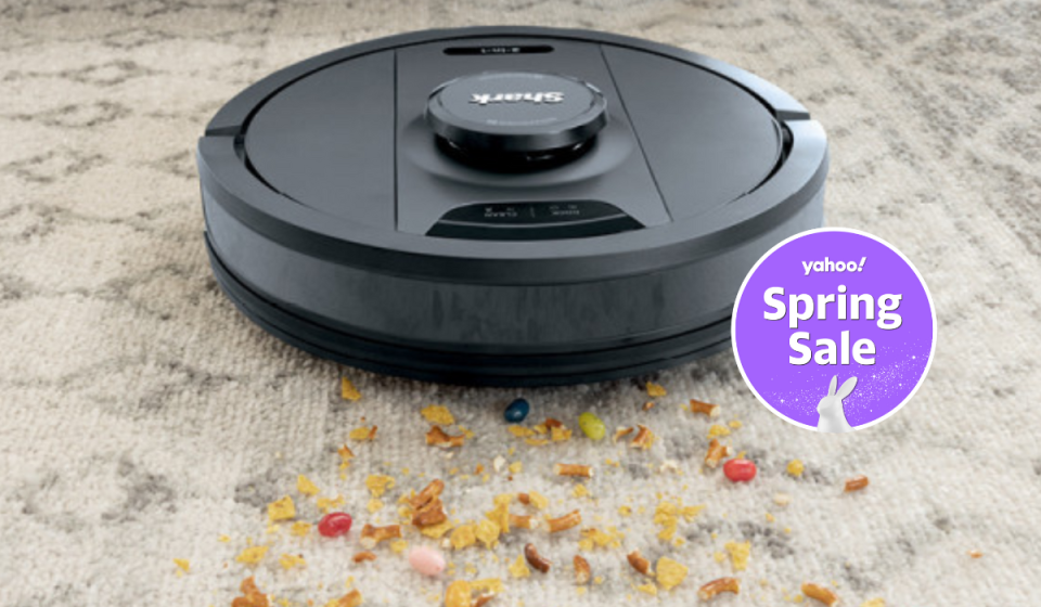 the shark robot vacuum and mop cleaning up food crumbs on a carpet