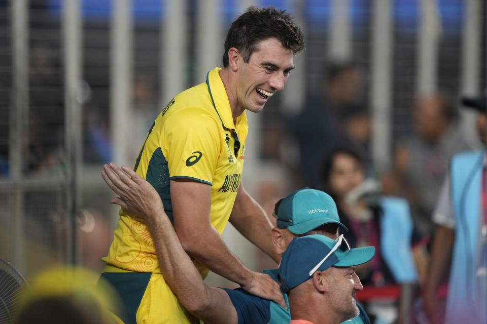 Australia's captain Pat Cummins shares a lighter moment with the coaching staff members during the ICC Men's Cricket World Cup final match between Australia and India in Ahmedabad, India, Sunday, Nov.19, 2023. (AP Photo/Mahesh Kumar A.)