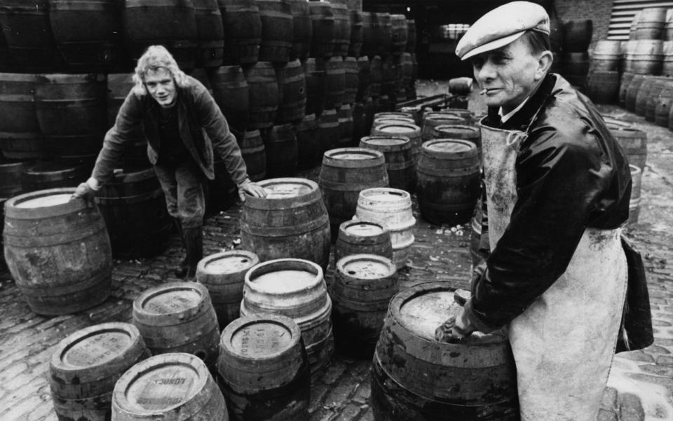 Workers at Young's brewery unbung barrels for filling with beer, December 1974 - Hulton Archive/Evening Standard/Getty Images